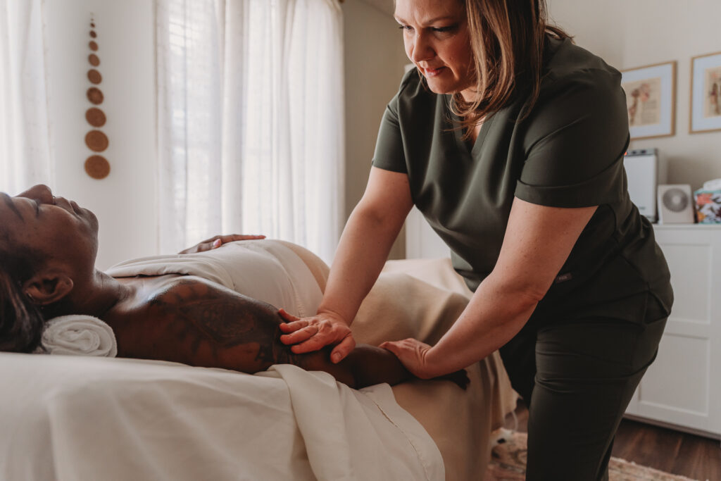 Image of Kristin Woudstra massaging a woman's arm\